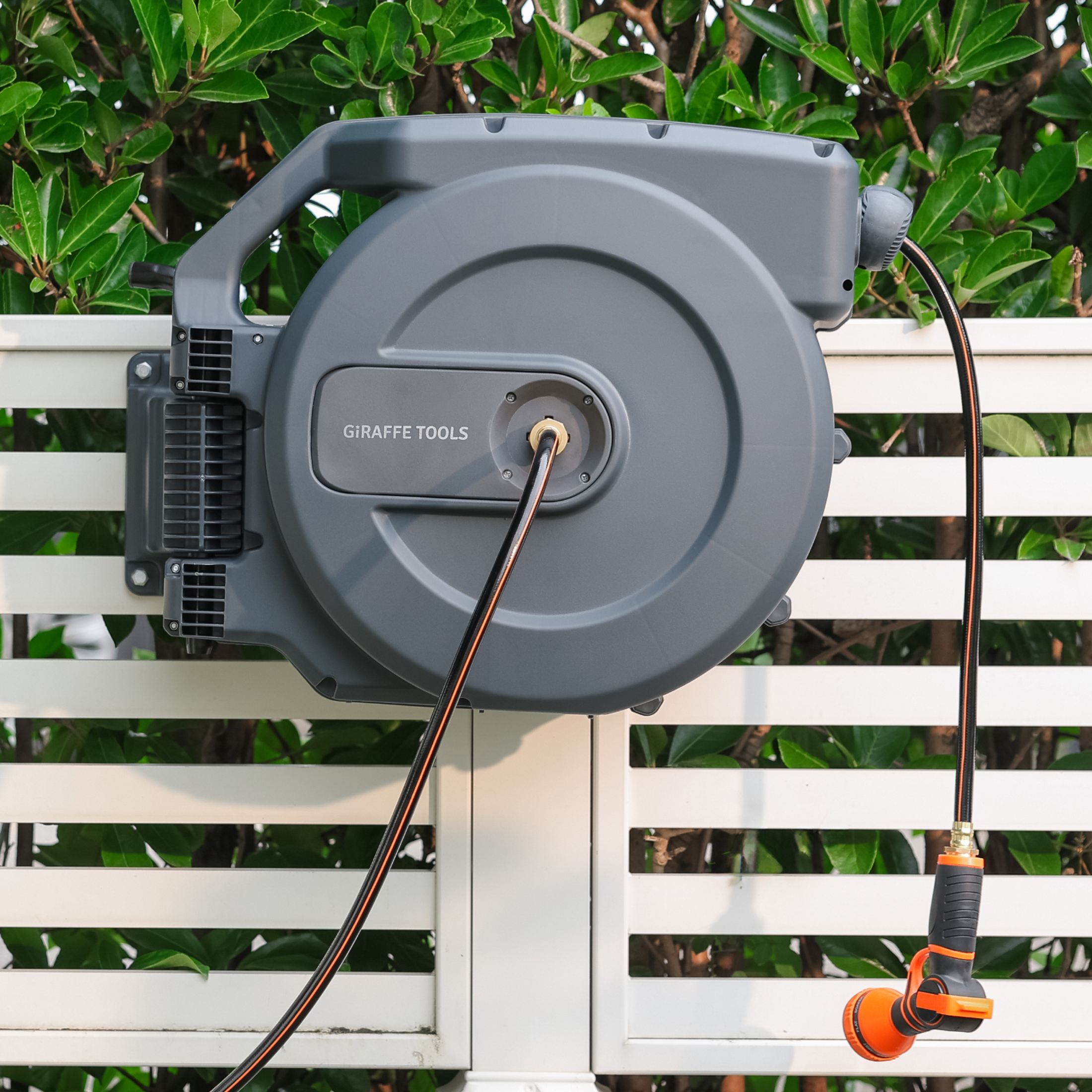 Giraffe Tools Retractable Garden Hose Reel-1/2in-155ft Features a wall-mounted hose reel with nozzle for neat garden watering.