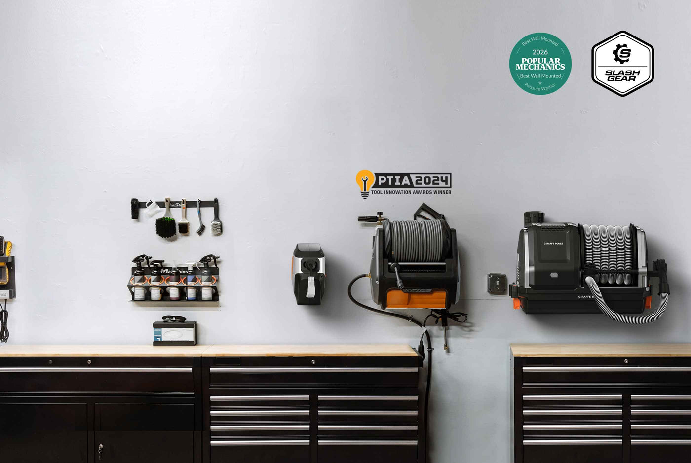 Giraffe Tools Dream Garage Bundle Banner: A wall-mounted garage organizer system with hooks, a tool rack, a hose reel, and a vacuum attachment mounted above dark tool cabinets against a white wall. Two certification badges are visible in the top right corner.